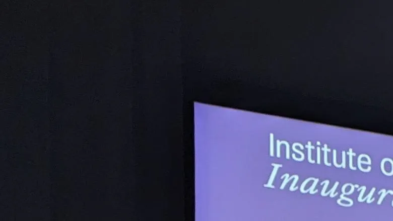 Professor Sally Marlow in front of a screen with the title of her talk Never Too Late