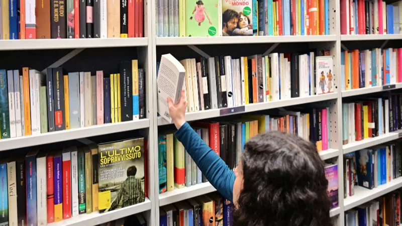 Person pulling a book from a bookshelf